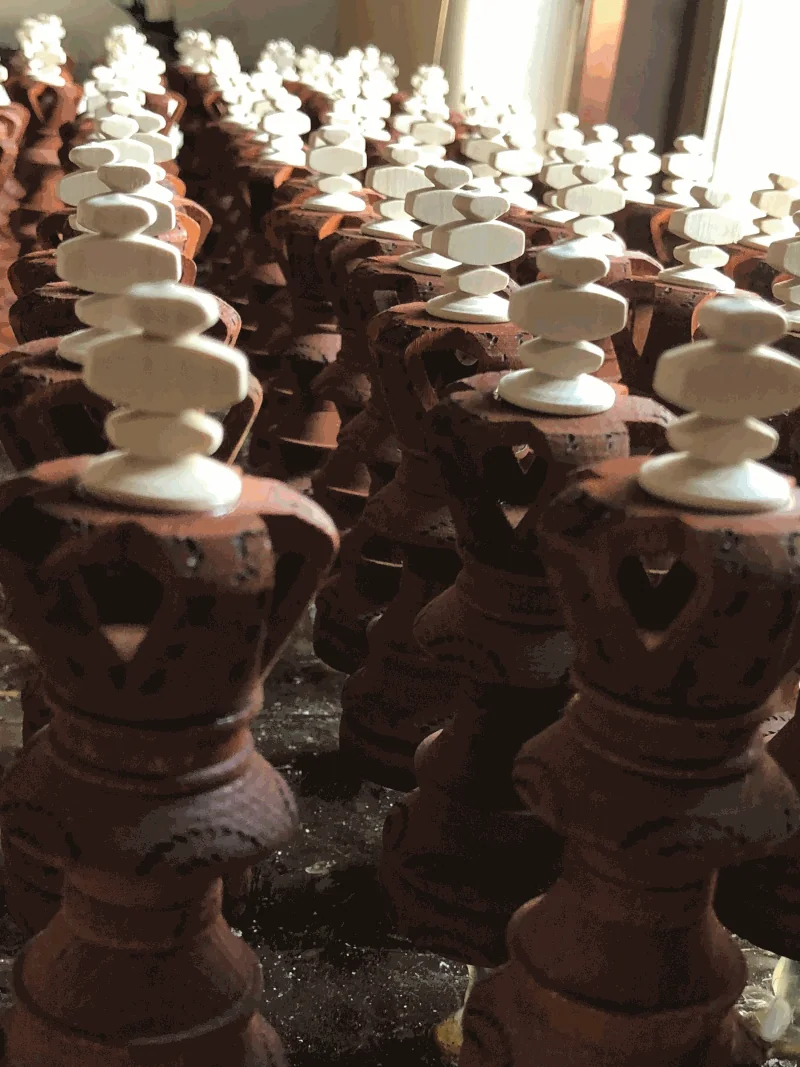 Filas de reyes de madera teñida en oscuro, alineados para secar