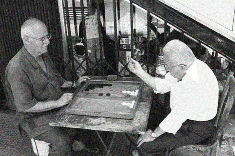 Foto de archivo en blanco y negro: dos hombres juegan al tavli