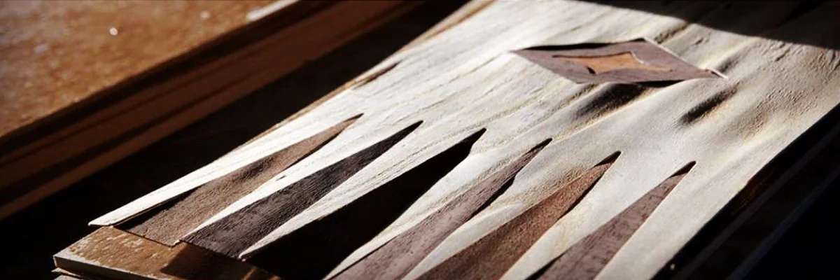 Colocación a mano de las puntas de marquetería en un tablero de backgammon