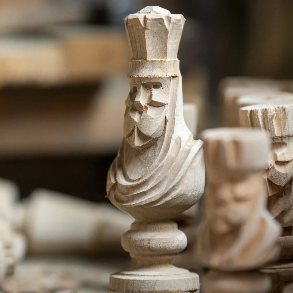 Pièces d’échecs sculptées à la main dans le bois brut, sur l’établi de l’atelier