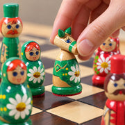 Jeu d’échecs La Matriochka — une main déplace une pièce