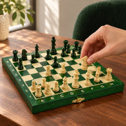 Jeu d’échecs Le Petit Nomade vert — une main déplace une pièce