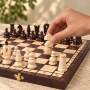 Jeu d’échecs Le Trianon — une main déplace une pièce