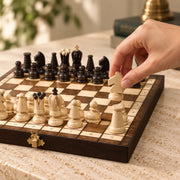 Jeu d’échecs Le Petit Trianon — une main déplace une pièce