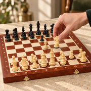 Jeu d’échecs Le Régence n°4 — une main déplace une pièce