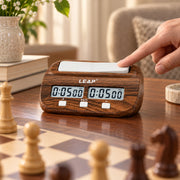 Pendule d’échecs numérique effet bois — main qui appuie sur la pendule