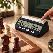 Pendule d’échecs numérique noire à écran LCD — main qui appuie sur la pendule